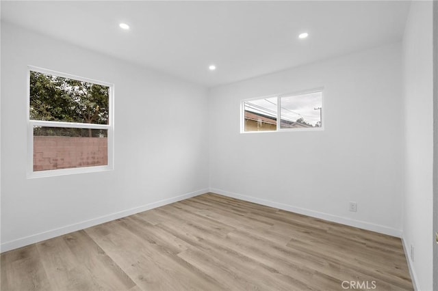 unfurnished room with recessed lighting, baseboards, and light wood finished floors