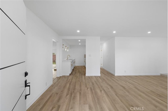 interior space with a sink, light wood-style floors, and recessed lighting