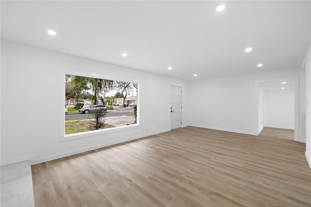 empty room featuring recessed lighting, light wood-type flooring, and baseboards