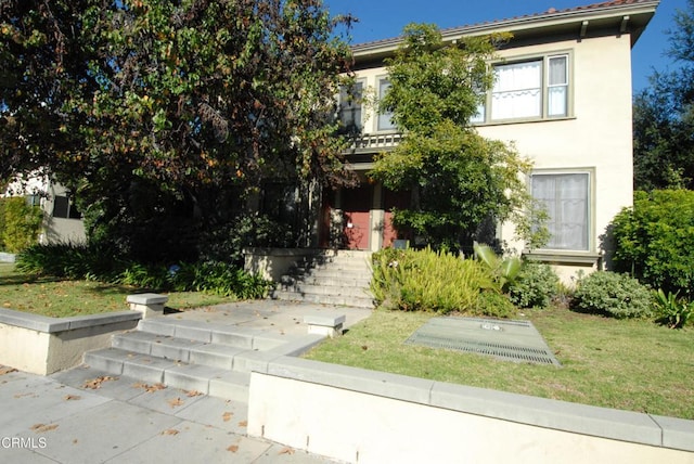 view of front of home with stucco siding and a front yard