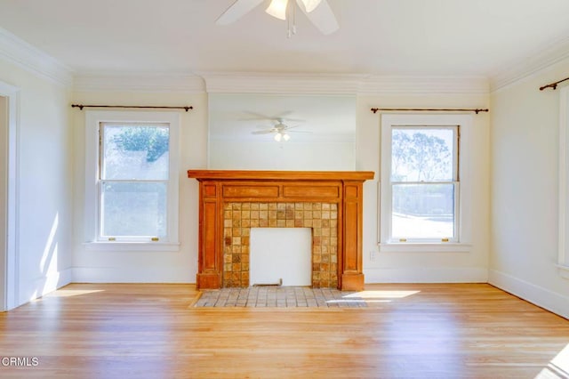 unfurnished living room featuring a tiled fireplace, plenty of natural light, and crown molding