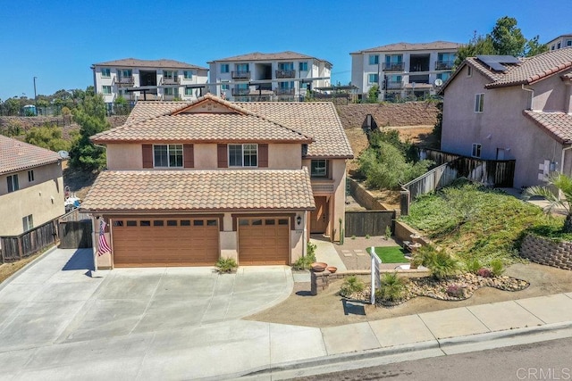 view of front facade featuring fence, stucco siding, concrete driveway, a tiled roof, and a residential view