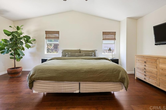 bedroom featuring vaulted ceiling, multiple windows, wood finished floors, and baseboards