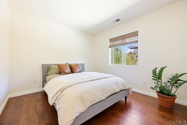 bedroom with hardwood / wood-style flooring, baseboards, and visible vents