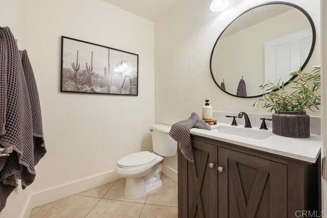 bathroom featuring tile patterned floors, toilet, vanity, and baseboards