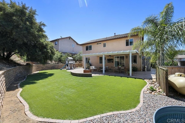 view of yard with ceiling fan, a patio area, a fenced backyard, and a playground