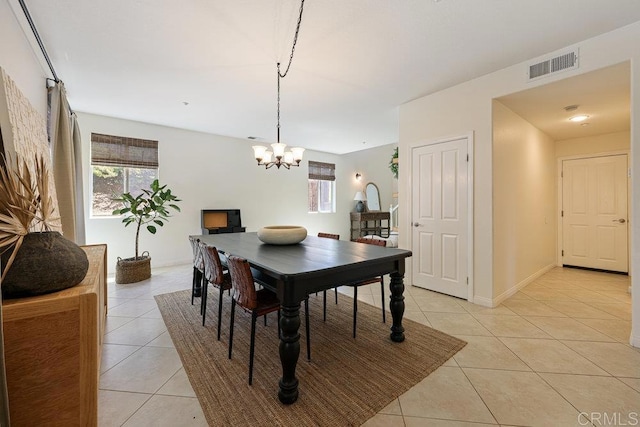 dining space with light tile patterned floors, visible vents, baseboards, and a notable chandelier