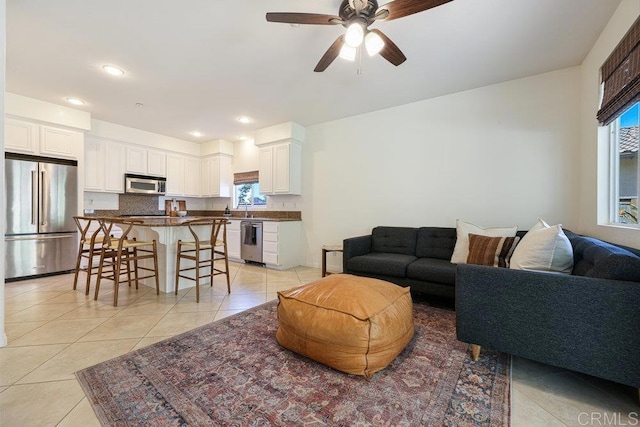 living area featuring light tile patterned floors, ceiling fan, and recessed lighting