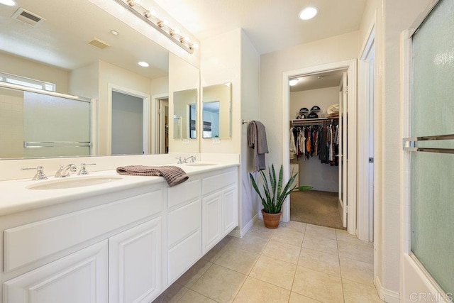 bathroom featuring a sink, visible vents, an enclosed shower, and tile patterned floors