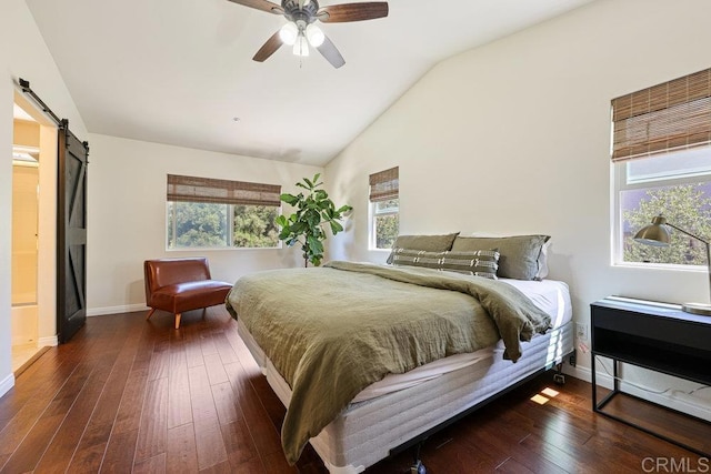 bedroom featuring a barn door, wood-type flooring, baseboards, and vaulted ceiling