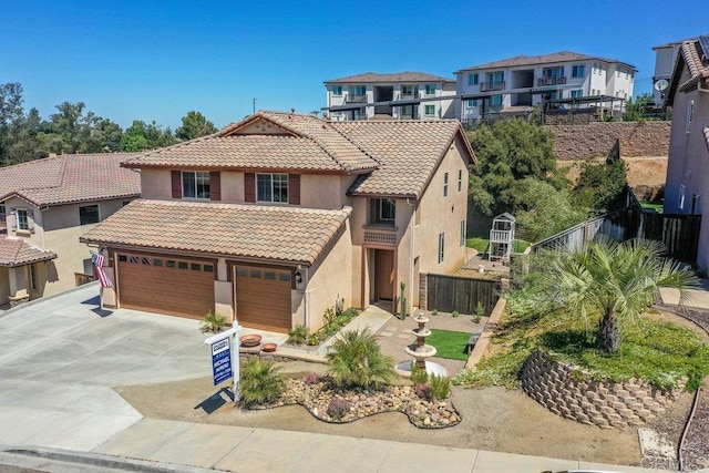 view of front of home featuring stucco siding, fence, concrete driveway, and a tile roof