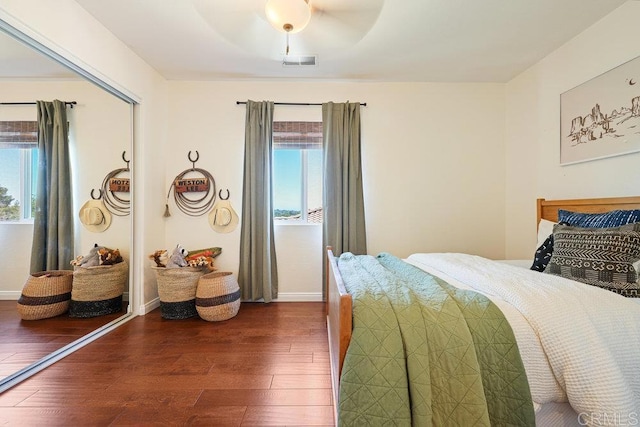 bedroom with visible vents, multiple windows, baseboards, and dark wood-style flooring