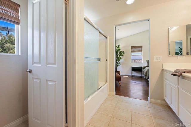 full bathroom with tile patterned flooring, vanity, enclosed tub / shower combo, and baseboards