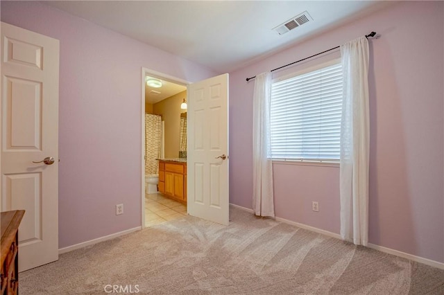 unfurnished bedroom with connected bathroom, baseboards, visible vents, and light carpet