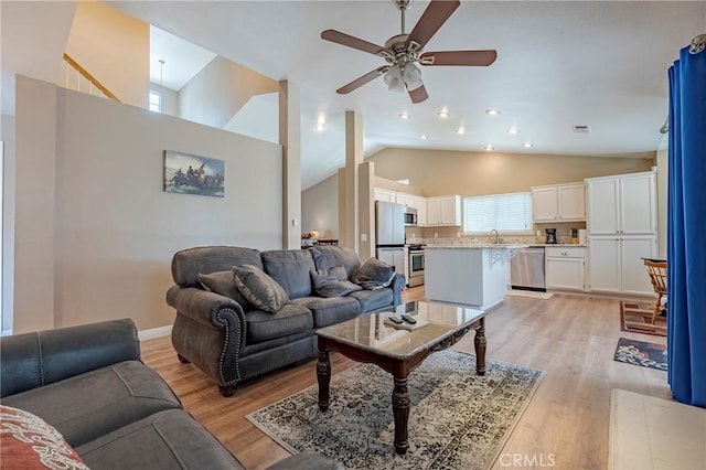 living room with high vaulted ceiling, visible vents, light wood finished floors, and ceiling fan