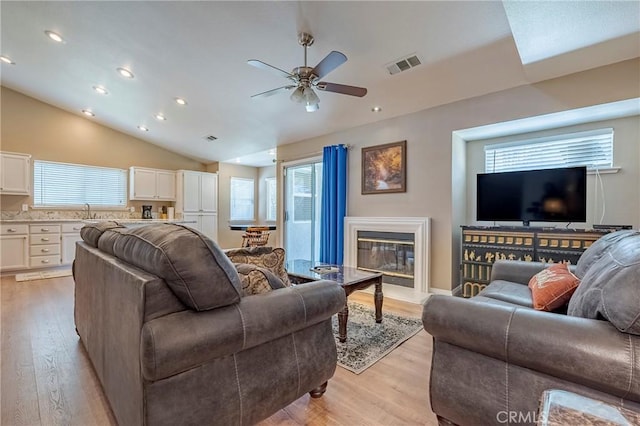 living room featuring plenty of natural light, light wood-style floors, and visible vents