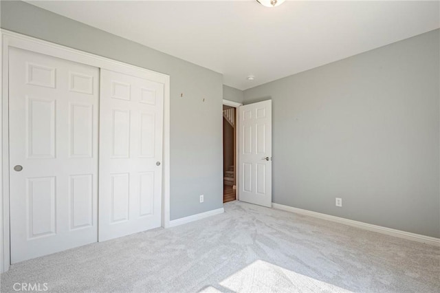 unfurnished bedroom with a closet, baseboards, and carpet floors