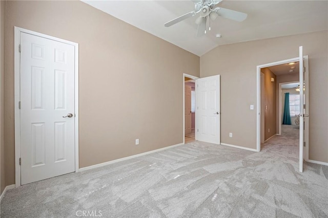 unfurnished bedroom with light carpet, ceiling fan, baseboards, and vaulted ceiling