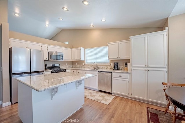 kitchen with white cabinets, light wood-style flooring, appliances with stainless steel finishes, and a center island