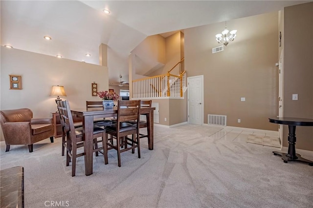 carpeted dining area with visible vents, baseboards, a notable chandelier, and high vaulted ceiling