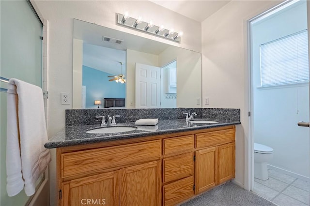 bathroom with double vanity, toilet, visible vents, and a sink