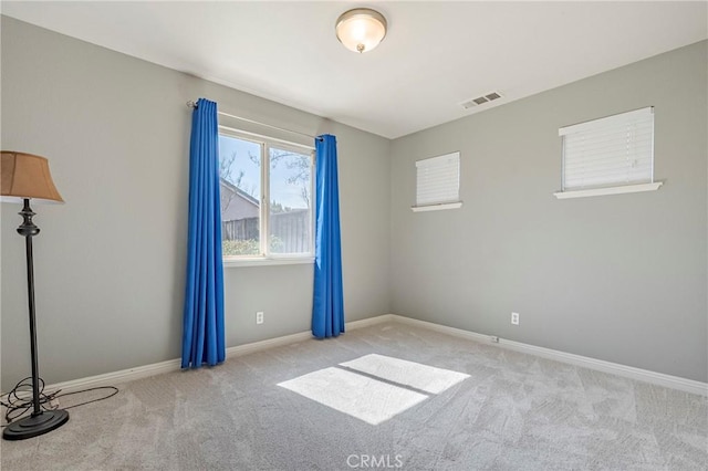 carpeted empty room featuring visible vents and baseboards