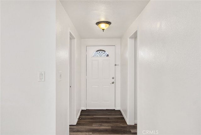 entryway with dark wood finished floors and baseboards