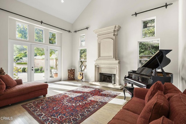living area with recessed lighting, high vaulted ceiling, a fireplace with raised hearth, and wood finished floors