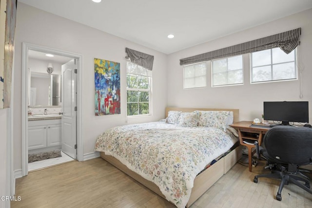 bedroom with a sink, ensuite bathroom, recessed lighting, light wood-style flooring, and baseboards