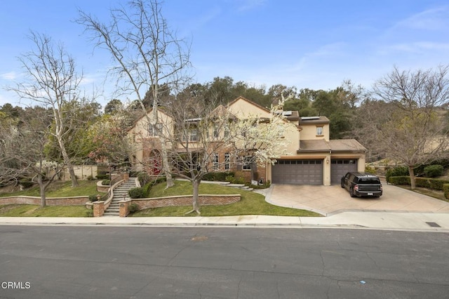 view of front of house with an attached garage, roof mounted solar panels, stucco siding, and driveway