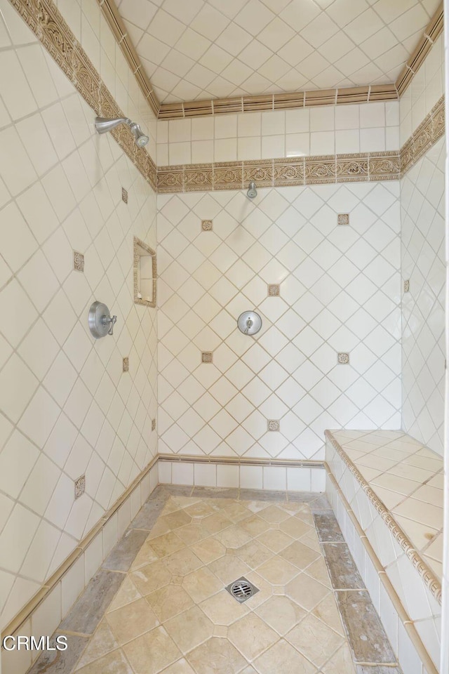 bathroom with tile patterned floors and a tile shower