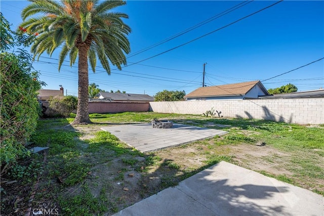 view of yard with an outdoor fire pit, a patio, and fence