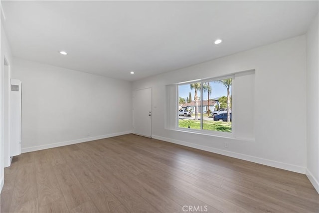 spare room with wood finished floors and baseboards