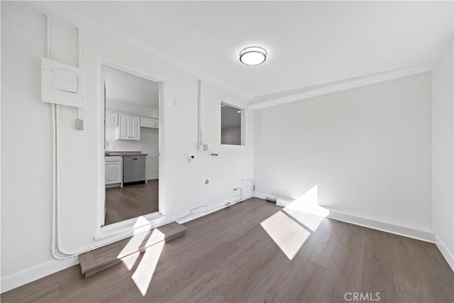 unfurnished room with a sink, baseboards, and dark wood-style floors