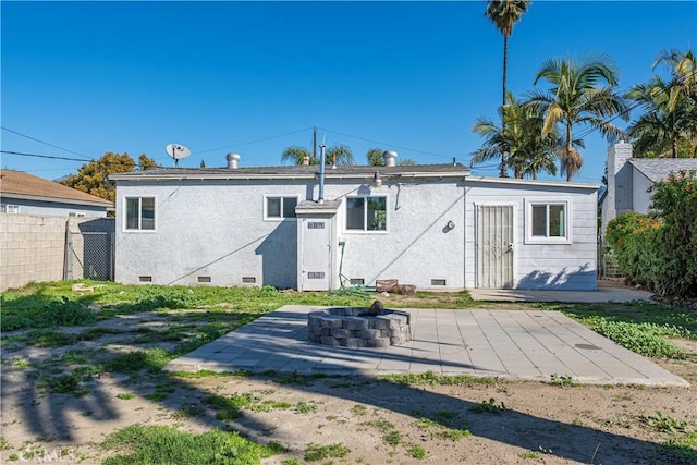 rear view of house featuring crawl space, a patio area, stucco siding, and fence