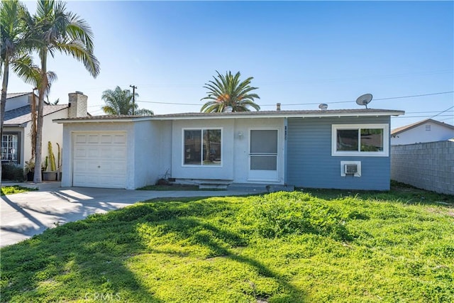 ranch-style home featuring a garage, a front yard, driveway, and fence