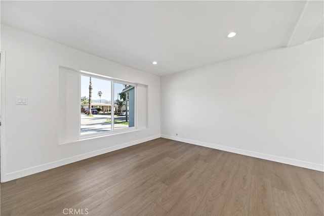 empty room featuring dark wood-type flooring, recessed lighting, and baseboards