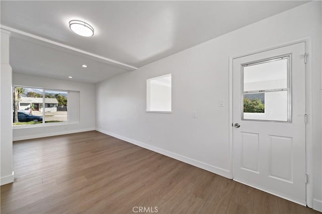 unfurnished room with recessed lighting, wood finished floors, and baseboards