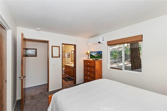 bedroom featuring a wall unit AC, connected bathroom, a closet, dark colored carpet, and baseboards