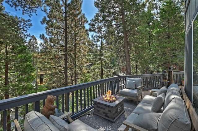 deck with an outdoor living space with a fire pit