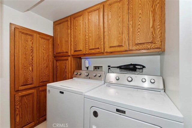 clothes washing area with cabinet space and washing machine and clothes dryer