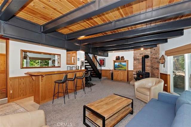 living room with a wood stove, indoor bar, and wainscoting