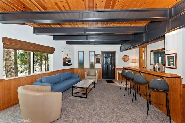 carpeted living room with beam ceiling, wooden walls, a wainscoted wall, and wooden ceiling