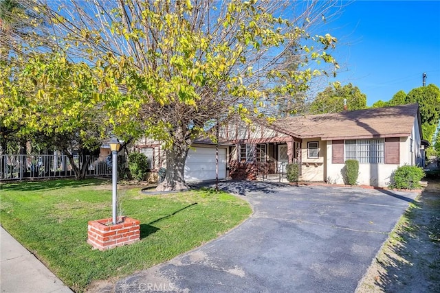 view of front of home with a front lawn, fence, aphalt driveway, stucco siding, and an attached garage