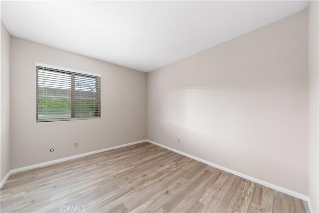 unfurnished room featuring baseboards and light wood-style floors