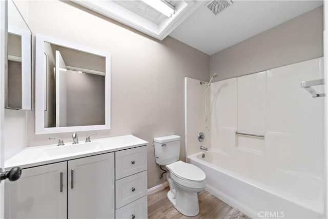 full bath featuring visible vents, toilet, shower / bathtub combination, wood finished floors, and vanity