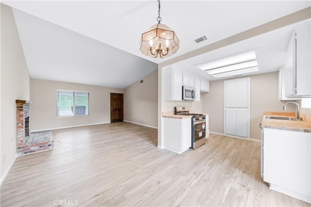 kitchen featuring visible vents, appliances with stainless steel finishes, light countertops, and a sink