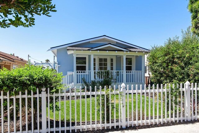 view of front of property with a fenced front yard and covered porch