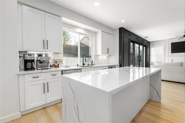 kitchen with a sink, a healthy amount of sunlight, and light wood finished floors