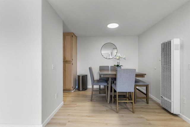 dining area featuring light wood finished floors, a heating unit, and baseboards